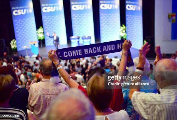 Supporter cheering on former German Defence Minister Karl-Theodor zu Guttenberg with a scarf while he leaves the stage during a CSU electoral...