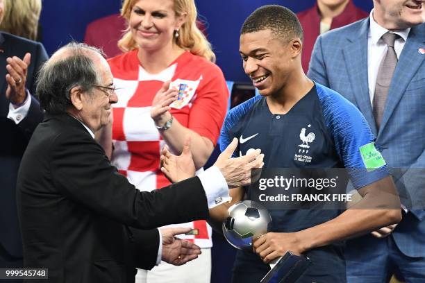 France's forward Kylian Mbappe receives the the FIFA Young Player award from Fren Football Federation president Noel Le Graet during the trophy...