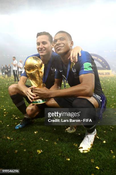 Florian Thauvin and Kylian Mbappe of France celebrate victory with the World Cup trophy following the 2018 FIFA World Cup Final between France and...