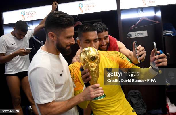 Olivier Giroud of France and Alphonse Areola of France celebrate with the World Cup Trophy in the dressing room following their sides victory in the...