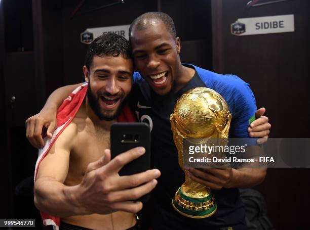 Nabil Fekir of France and Djibril Sidibe of France celebrate with the World Cup Trophy in the dressing room following their sides victory in the 2018...