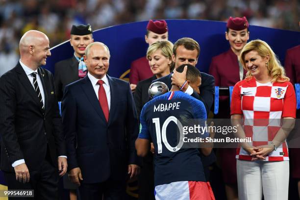 French President Emmanuel Macron awards Kylian Mbappe of France with the FIFA Young Player Award as President of Russia Vladimir Putin and President...