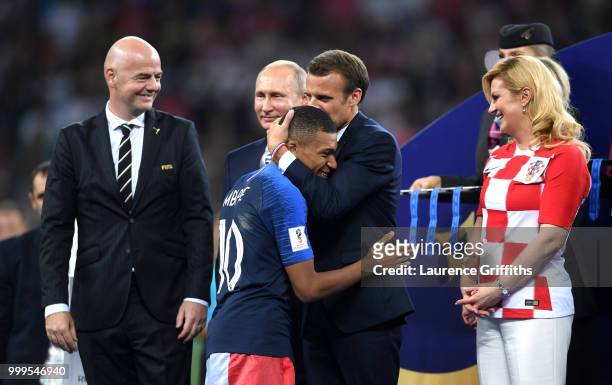 French President Emmanuel Macron awards Kylian Mbappe of France with the FIFA Young Player Award as President of Russia Vladimir Putin and President...