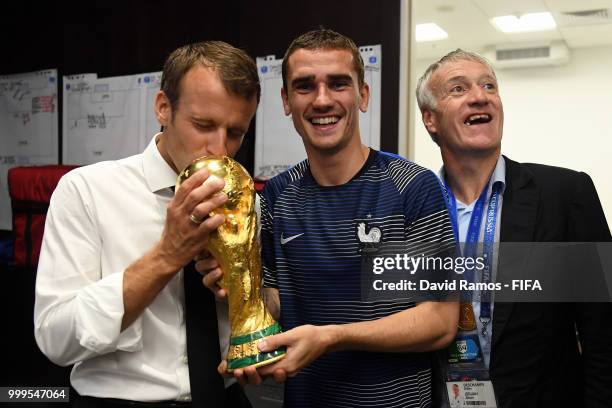 Antoine Griezmann of France and The President of France, Emmanuel Macron, celebrate with the World Cup Trophy in the dressing room following France's...