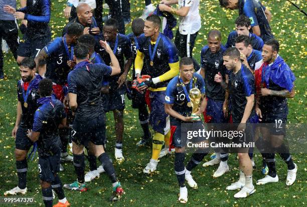 Kylian Mbappe of France celebrates with the World Cup trophy and team mates following the 2018 FIFA World Cup Final between France and Croatia at...