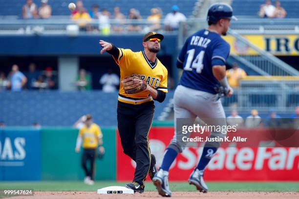 Jordy Mercer of the Pittsburgh Pirates turns a double play in the second inning against Hernan Perez of the Milwaukee Brewers at PNC Park on July 15,...