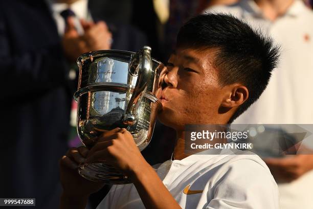 Taiwan's Tseng Chun Hsin holds up his trophy after beating Britain's Jack Draper in their boys's singles final match on the thirteenth day of the...