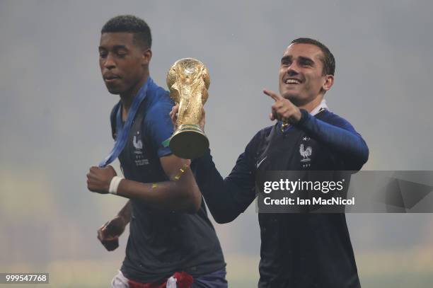 Presnel Kimpembe and Antoine Griezmann of France are seen with the trophy during the 2018 FIFA World Cup Russia Final between France and Croatia at...