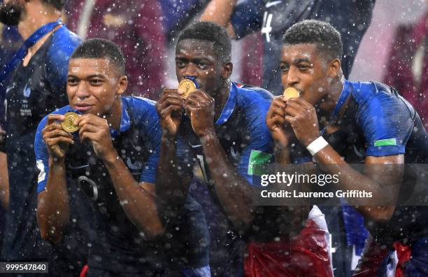 Kylian Mbappe, Ousmane Dembele and Presnel Kimpembe of France celebrate victory following the 2018 FIFA World Cup Final between France and Croatia at...