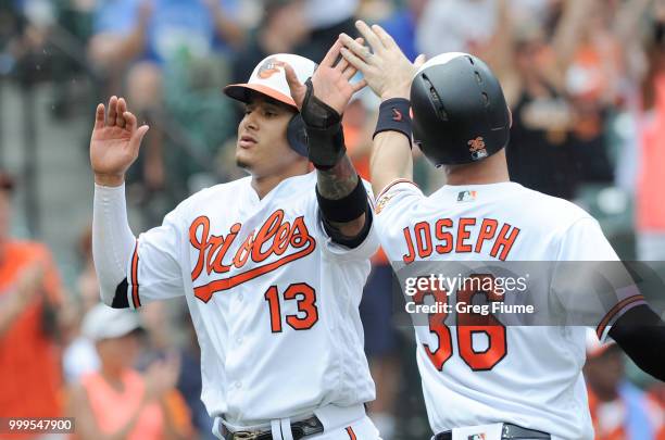 Manny Machado of the Baltimore Orioles celebrates with Caleb Joseph after scoring in the third inning against the Texas Rangers at Oriole Park at...