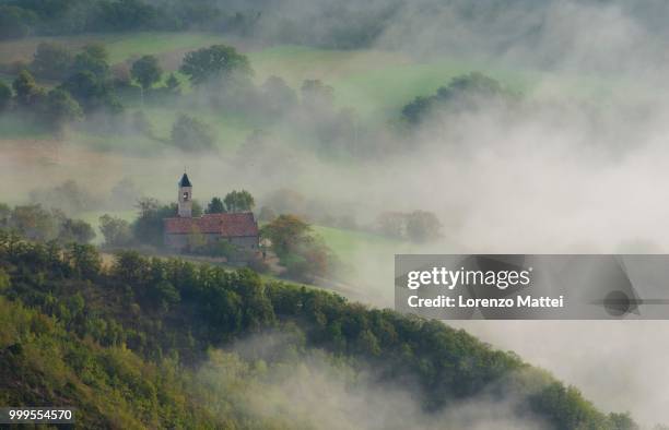 aerial view of a small church in fog, mount cucco, apennines, umbria, italy - lorenzo stock pictures, royalty-free photos & images