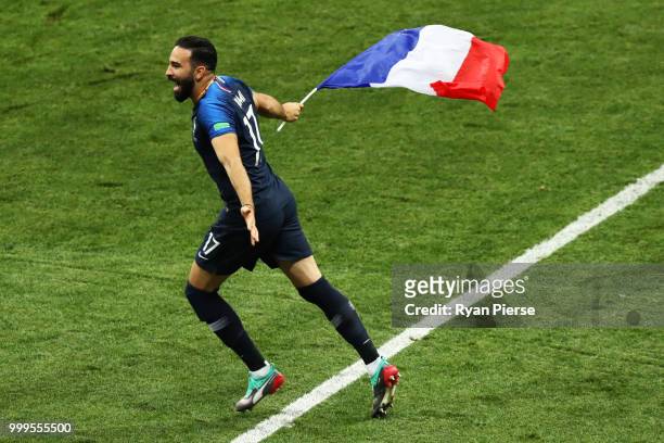 Adil Rami of France celebrates victory, displaying the French flag, following the 2018 FIFA World Cup Final between France and Croatia at Luzhniki...