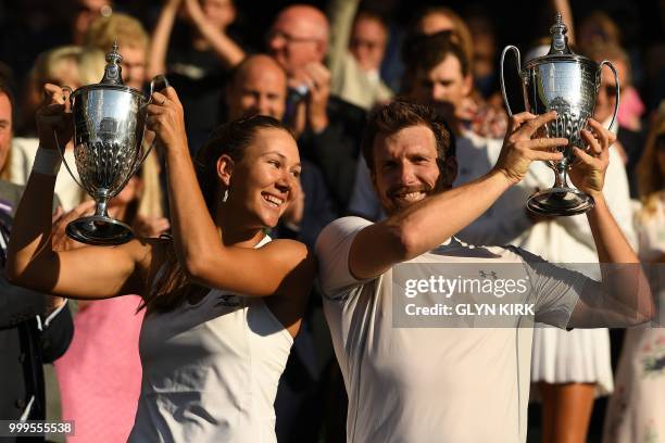 Austria's Alexander Peya and US player Nicole Melichar hold up their trophies after beating Britain's Jamie Murray and Belarus's Victoria Azarenka...