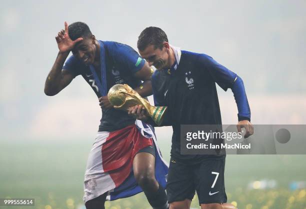 Presnel Kimpembe and Antoine Griezmann of France are seen with the trophy during the 2018 FIFA World Cup Russia Final between France and Croatia at...