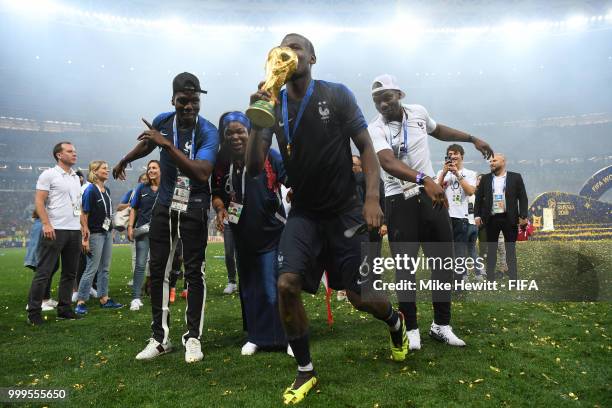 Paul Pogba of France celebrates with his family and the World Cup Trophy following his sides victory in the 2018 FIFA World Cup Final between France...