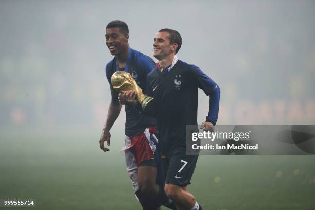 Presnel Kimpembe and Antoine Griezmann of France are seen with the trophy during the 2018 FIFA World Cup Russia Final between France and Croatia at...