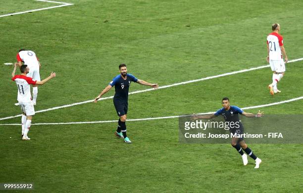 Olivier Giroud and Kylian Mbappe of France celebrate victory as Marcelo Brozovic, Dejan Lovren and Domagoj Vida of Croatia look dejected on the final...