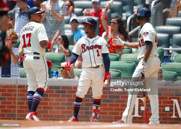 Johan Camargo of the Atlanta Braves celebrates scoring a run with teammates Ozzie Albies and Julio Teheran in the third inning of an MLB game against...