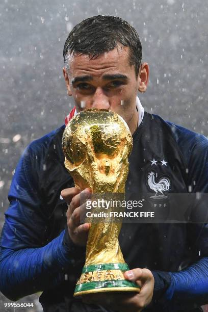 France's forward Antoine Griezmann kisses their World Cup trophy during the trophy ceremony at the end of the Russia 2018 World Cup final football...