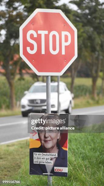 An election campaign poster of German chancellor Angela Merkel can be seen under a stop sign in Tellow, Germany, 31 August 2017. An election campaign...