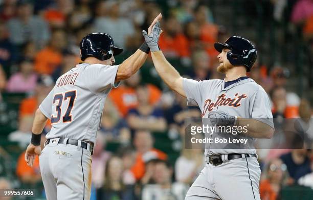 John Hicks of the Detroit Tigers high fives Jim Adduci after hitting a two-run home run in the second inning against the Houston Astros at Minute...