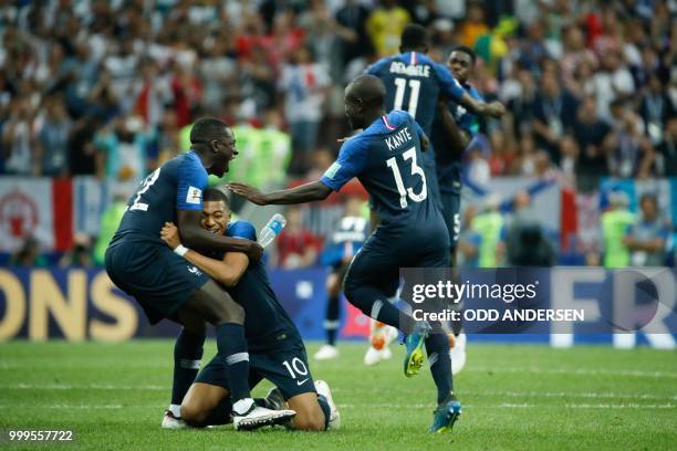 France's forward Kylian Mbappe celebrates with France's defender Benjamin Mendy and France's midfielder N'Golo Kante reacts after the final whistle...