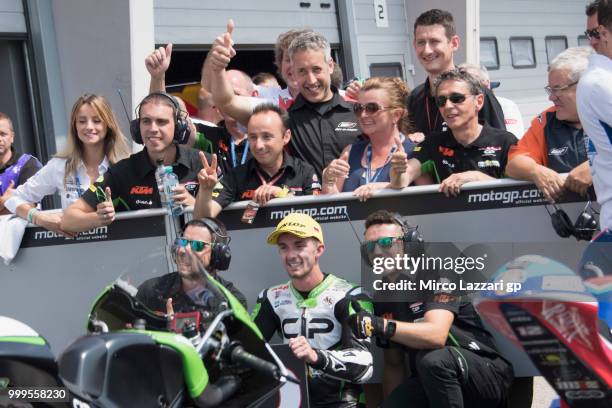 John McPhee of Great Britain and CIP Green Power celebrates the third place with team under the podium at the end of the Moto3 race during the MotoGp...