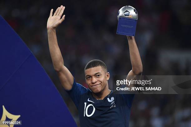 France's forward Kylian Mbappe carries the Best Young Player Award after the Russia 2018 World Cup final football match between France and Croatia at...