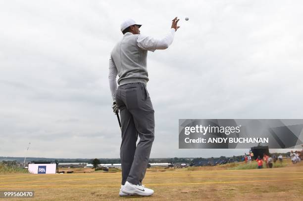 Golfer Tiger Woods catches a ball on the 3rd tee during the first practice session at The 147th Open Championship at Carnoustie, Scotland on July 15,...