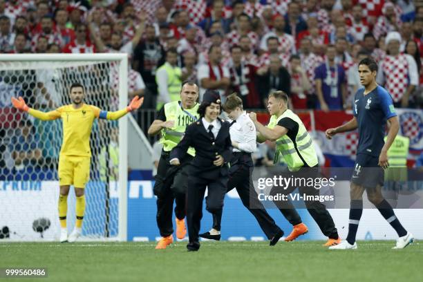 France goalkeeper Hugo Lloris, pitch intruder Pussy Riot, Raphael Varane of France during the 2018 FIFA World Cup Russia Final match between France...