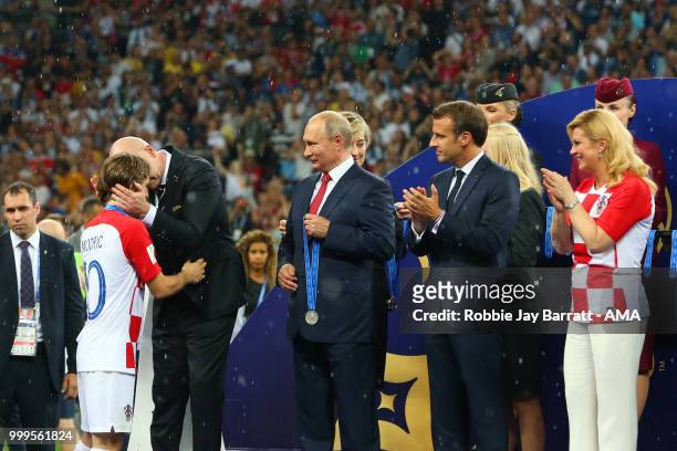 President Gianni Infantino presents Luka Modric of Croatia with his losers medal as Russia's President Vladimir Putin, and France's President...