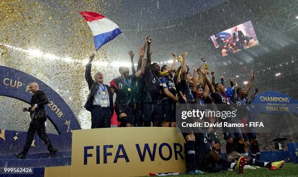 Didier Deschamps, Manager of France celebrates by waving a French flag as Hugo Lloris of France lifts the World Cup trophy following the 2018 FIFA...