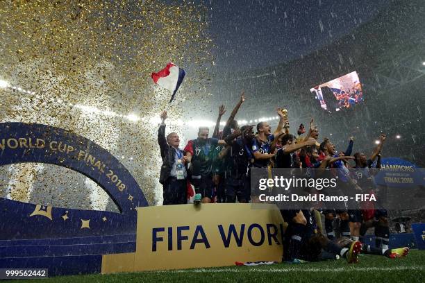 Didier Deschamps, Manager of France celebrates by waving a French flag as Hugo Lloris of France lifts the World Cup trophy following the 2018 FIFA...