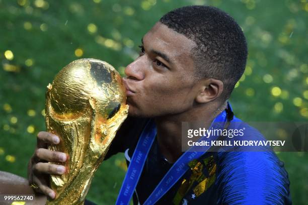 France's forward Kylian Mbappe kisses the trophy at the end of the Russia 2018 World Cup final football match between France and Croatia at the...