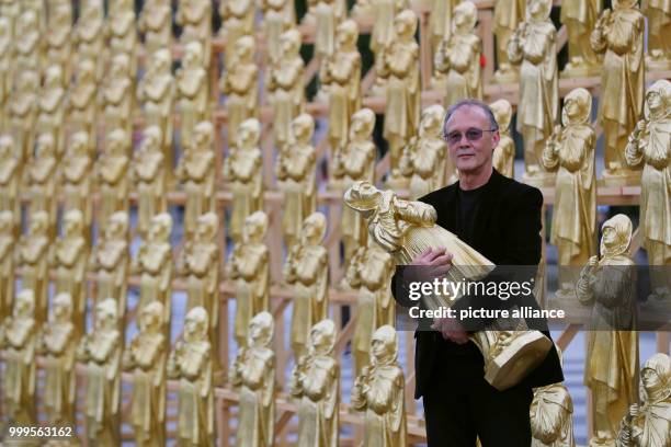 The concept artist Ottmar Hoerl stands between golden Madonna figurines in Nuremberg, Germany, 1 September 2017. Hoerl's art performance with 600...