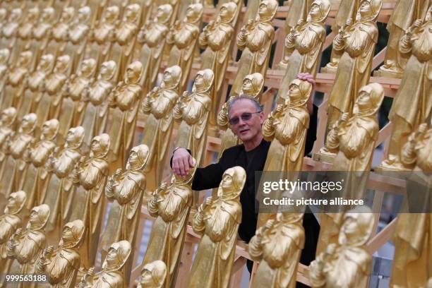 The concept artist Ottmar Hoerl stands between golden Madonna figurines in Nuremberg, Germany, 1 September 2017. Hoerl's art performance with 600...