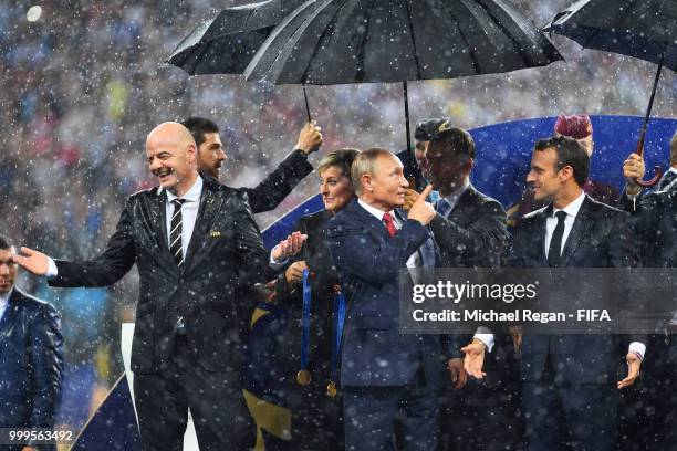 President Gianni Infantino, President of Russia Vladimir Putin and French President Emmanuel Macron chat on the stage following the 2018 FIFA World...
