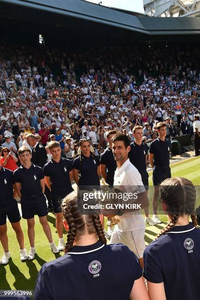 Serbia's Novak Djokovic holds the winners trophy after beating South Africa's Kevin Anderson 6-2, 6-2, 7-6 in their men's singles final match on the...