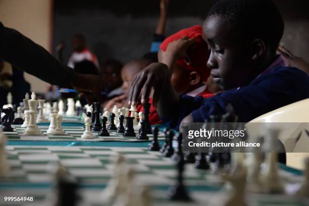 Young Kenyan playing chess during a tournament in Mukuru kwa Njenga, a slum of Nairobi , 15 July 2017. Adolescent Ugandans are also particpating in...