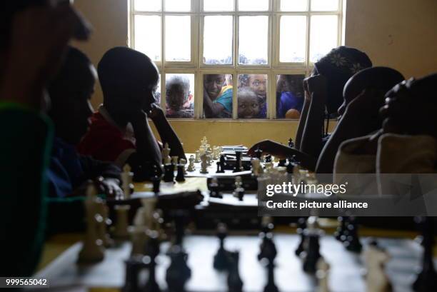 Young Kenyans playing chess during a tournament in Mukuru kwa Njenga, a slum of Nairobi , 15 July 2017. Young Ugandans are also particpating in this...