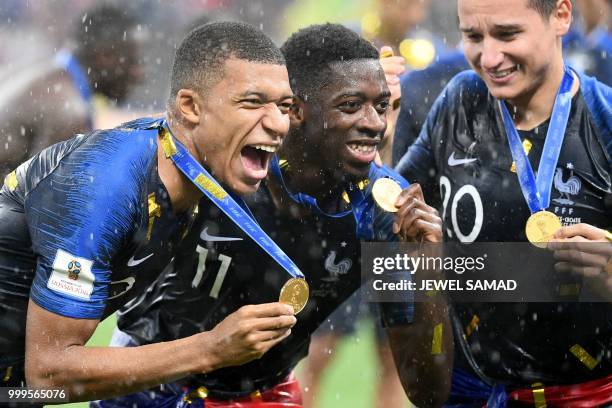France's forward Kylian Mbappe , France's forward Ousmane Dembele and France's forward Florian Thauvin celebrate with their medals after the Russia...