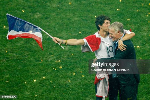 France's coach Didier Deschamps celebrates with his son Dylan Deschamps waving the French national flag during the trophy ceremony after winning the...