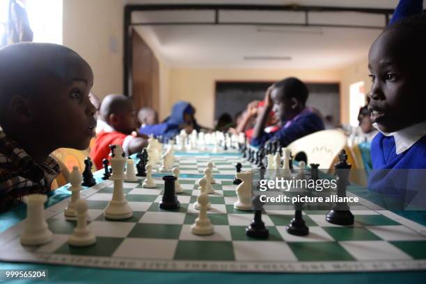 Two young Kenyans playing chess during a tournament in Mukuru kwa Njenga, a slum of Nairobi , 15 July 2017. Adolescent Ugandans are also particpating...