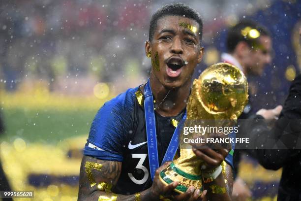 France's defender Presnel Kimpembe holds the World Cup trophy after winning the Russia 2018 World Cup final football match between France and Croatia...