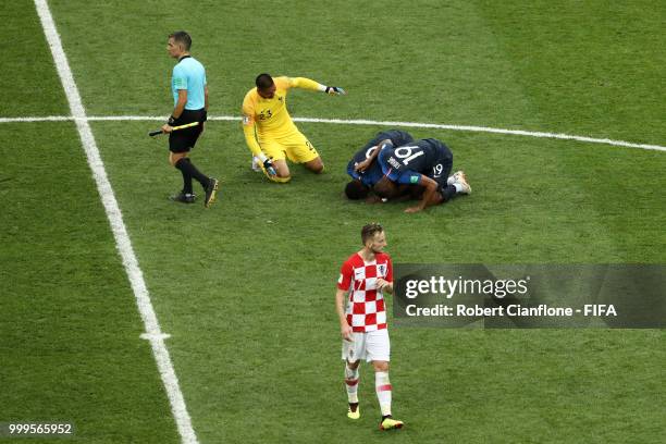 Ivan Rakitic of Croatia looks dejected as Djibril Sidibe, Alphonse Areola and Paul Pogba of France celebrate victory following the 2018 FIFA World...