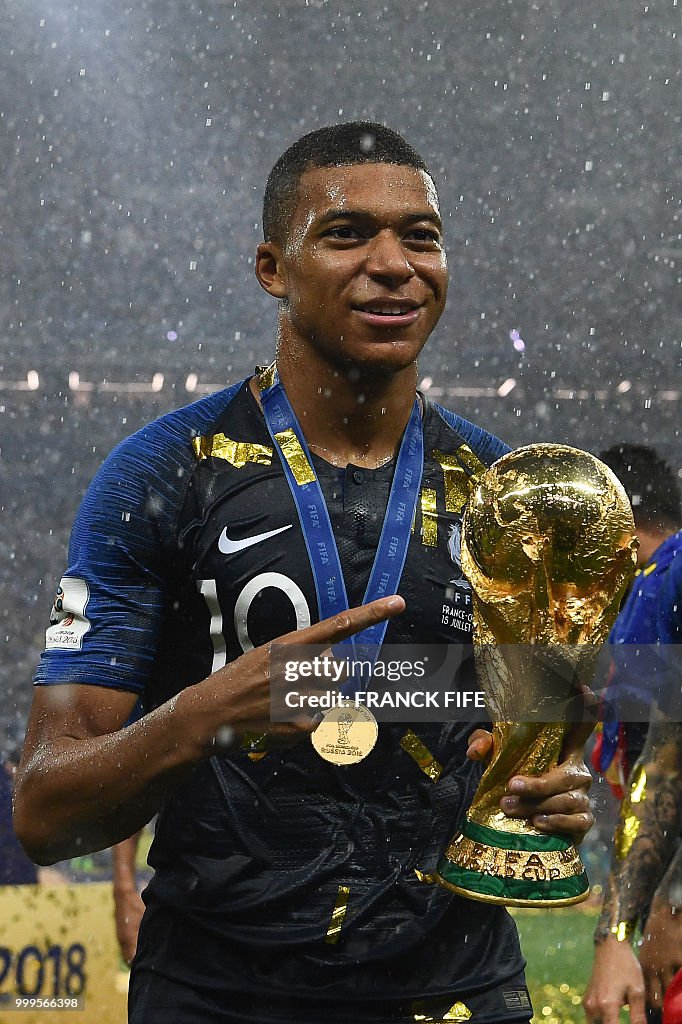 France s Forward Kylian Mbappe Holds The World Cup Trophy After france-s-forward-kylian-mbappe-holds-the-world-cup-trophy-after