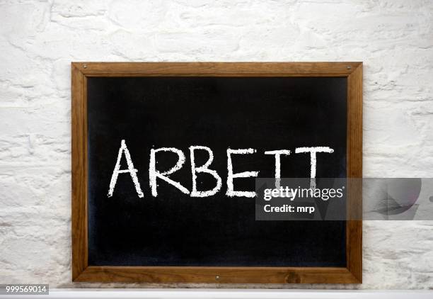 chalkboard with the word --arbeit--, german for work - arbeit stockfoto's en -beelden