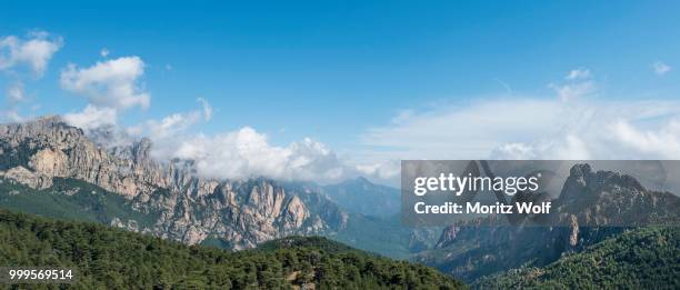 panoramic view over a valley, mountain slopes with rocky peaks surrounded by pine forests, cliffs, col de bavella, bavella massif, corsica, france - col stock pictures, royalty-free photos & images