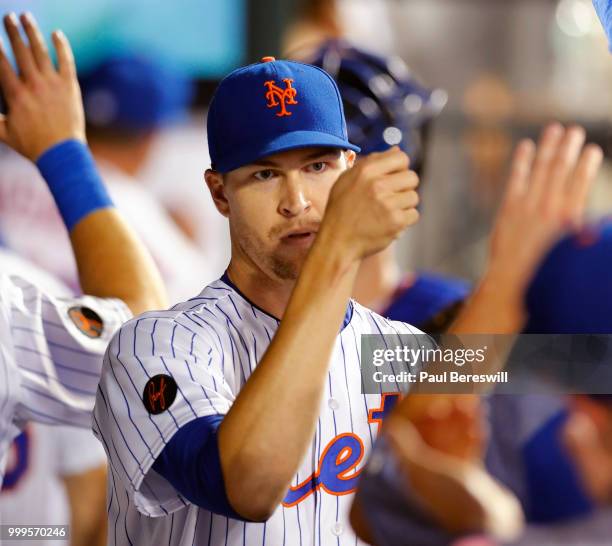 Jacob deGrom of the New York Mets gets congratulations from teammates in the dugout after pitching in the 8th inning in an MLB baseball game against...