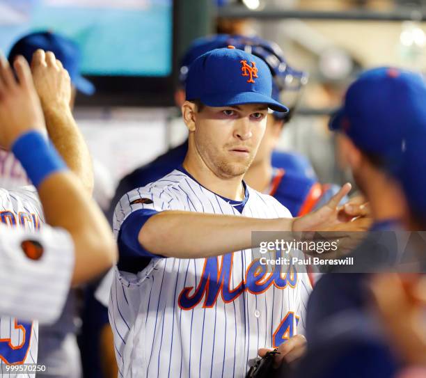 Jacob deGrom of the New York Mets gets congratulations from teammates in the dugout after pitching in the 8th inning in an MLB baseball game against...